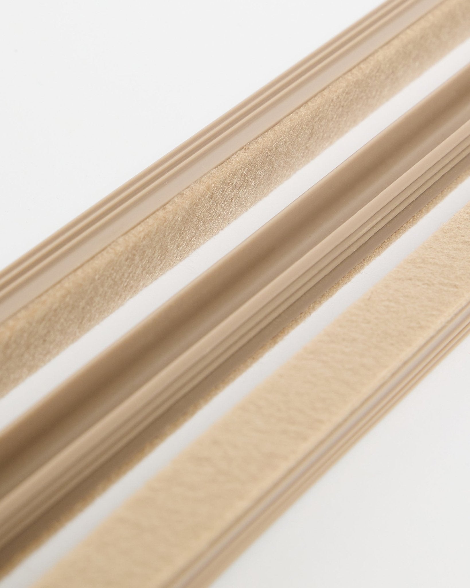 Beige WoodUpp Dupps Pop-on Cable Covers (3-pack) with felt texture and adhesive backing, shown on a white surface for cord organization.