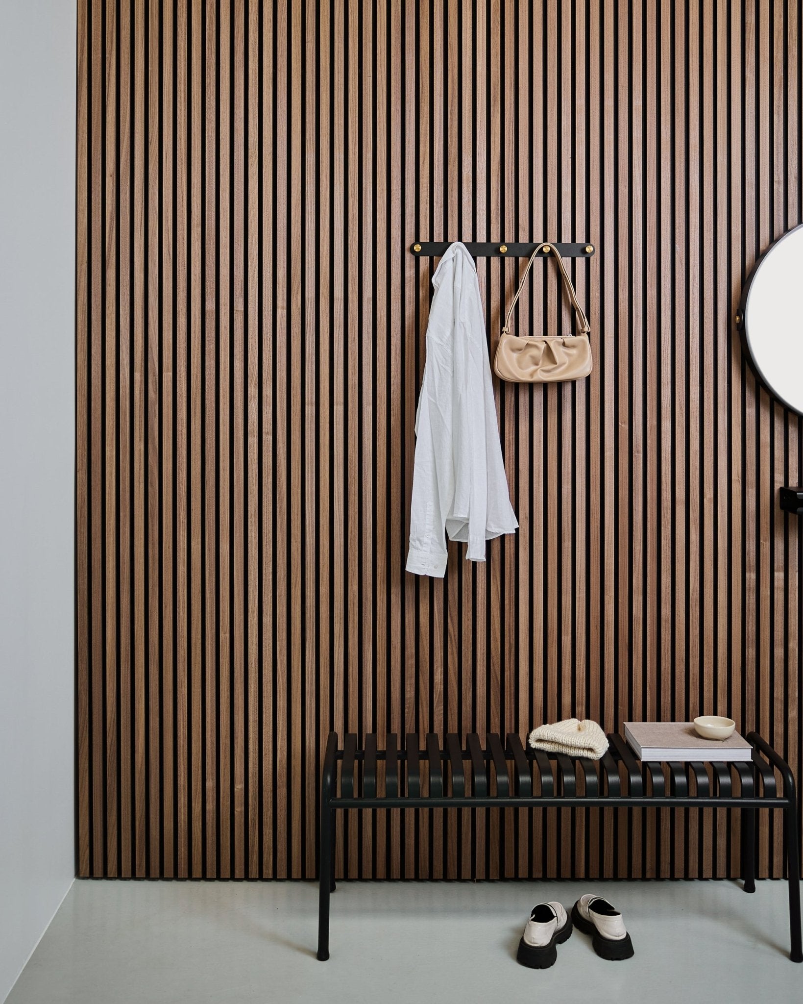 WoodUpp Norr Coat Hook Rack in black and brass holds a white shirt and beige bag above a black bench; white slippers are arranged neatly underneath.